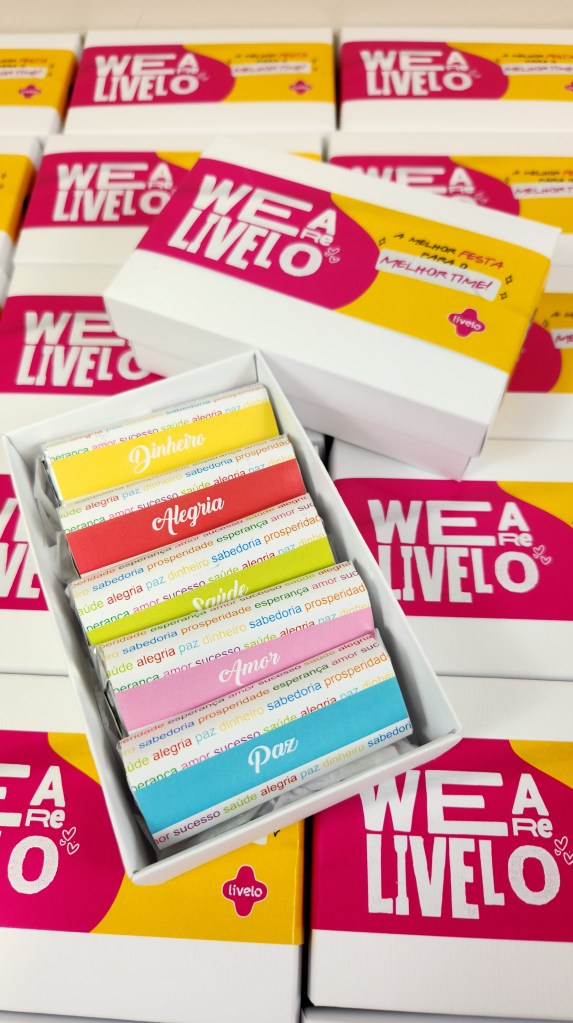 Caixa de mini chocolates personalizados para a empresa Livelo, cada barra representando um desejo: dinheiro, alegria, saúde, amor e paz — brinde corporativo criativo de fim de ano para colaboradores.
