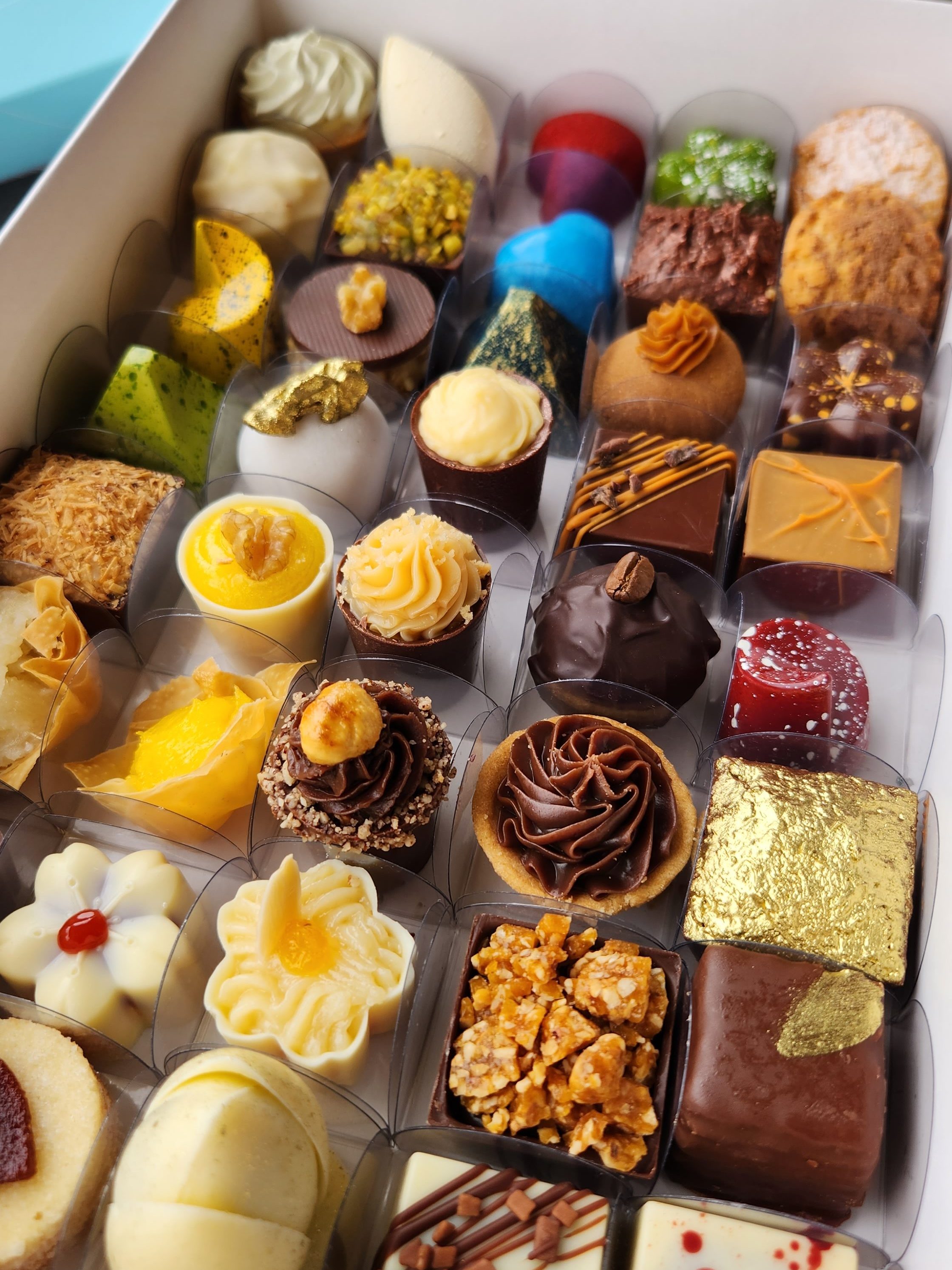 Caixa degustação com variedade de doces finos e gourmet para casamento, incluindo bombons, trufas e doces artesanais com diferentes sabores e acabamentos elegantes.
