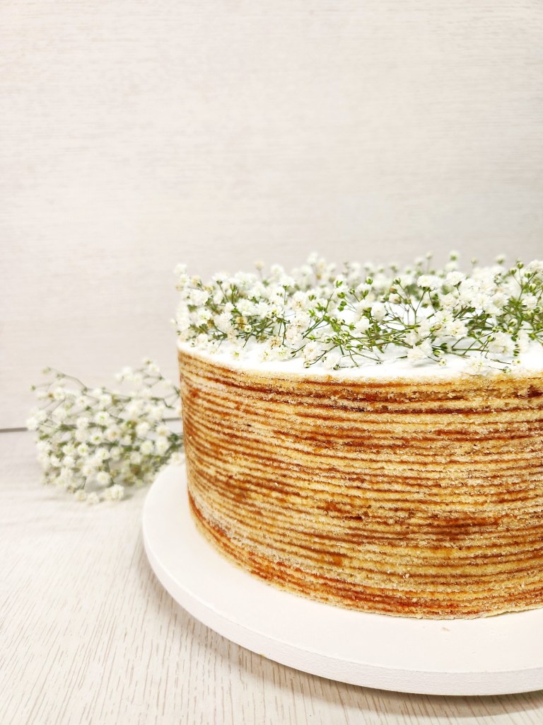 Bolo de rolo festa decorado com flores brancas delicadas, opção moderna e elegante para casamentos e celebrações especiais.